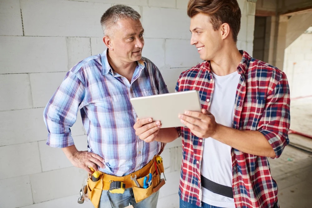 Two Dynamic Plumbing Works tradespeople reviewing a job on a tablet